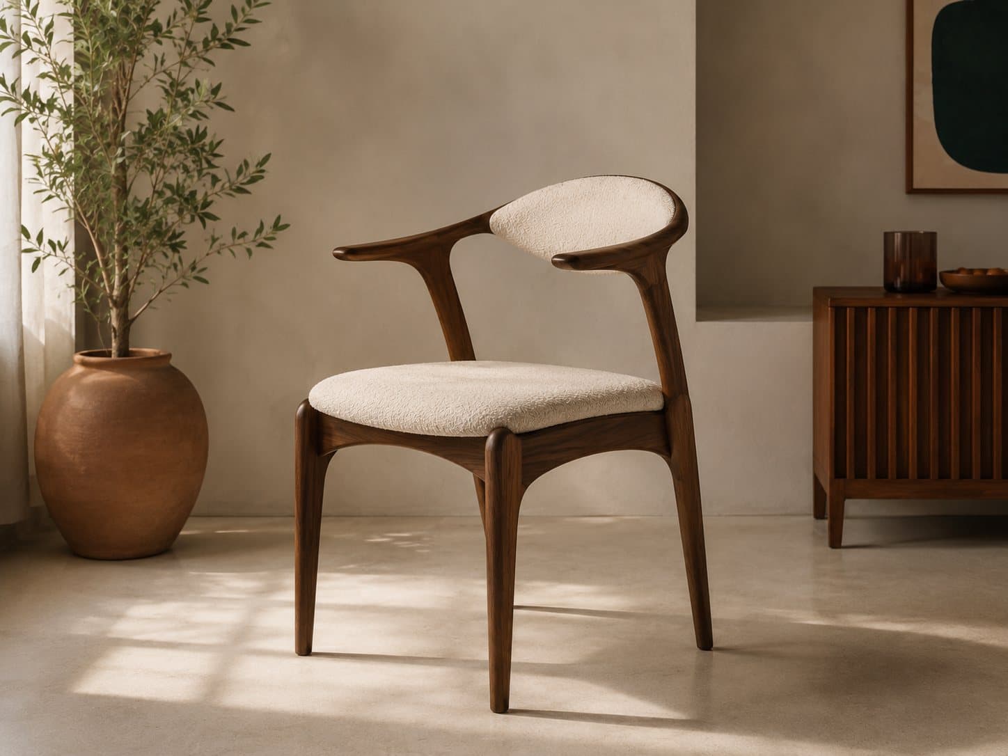 The Curva dining chair in oiled walnut with a bouclé-wrapped seat